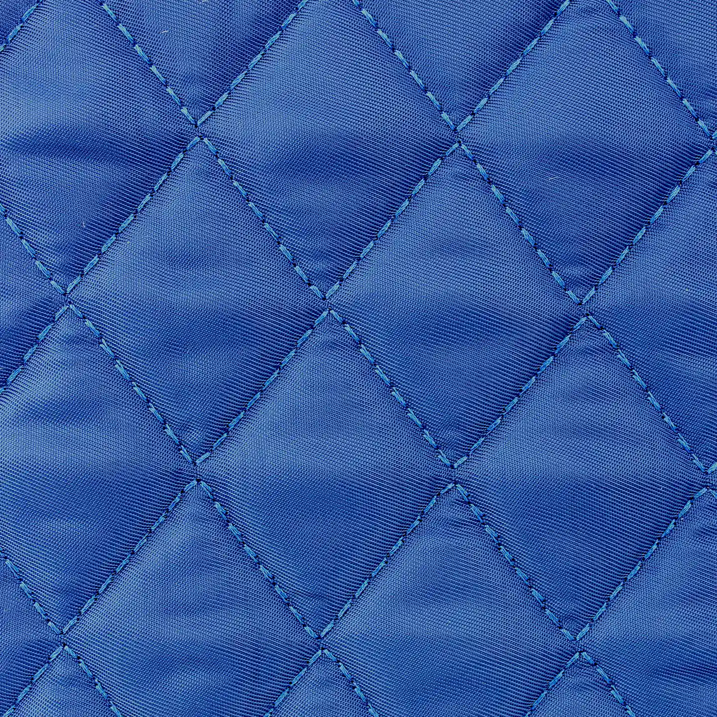 Close-up of the blue Tennis Tote's nylon surface and diamond-pattern stitching.