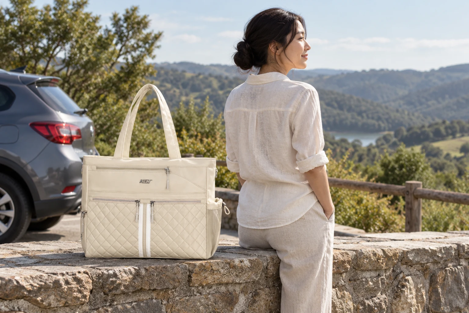 Cream NST Tennis Tote beside a car at a scenic weekend stop.